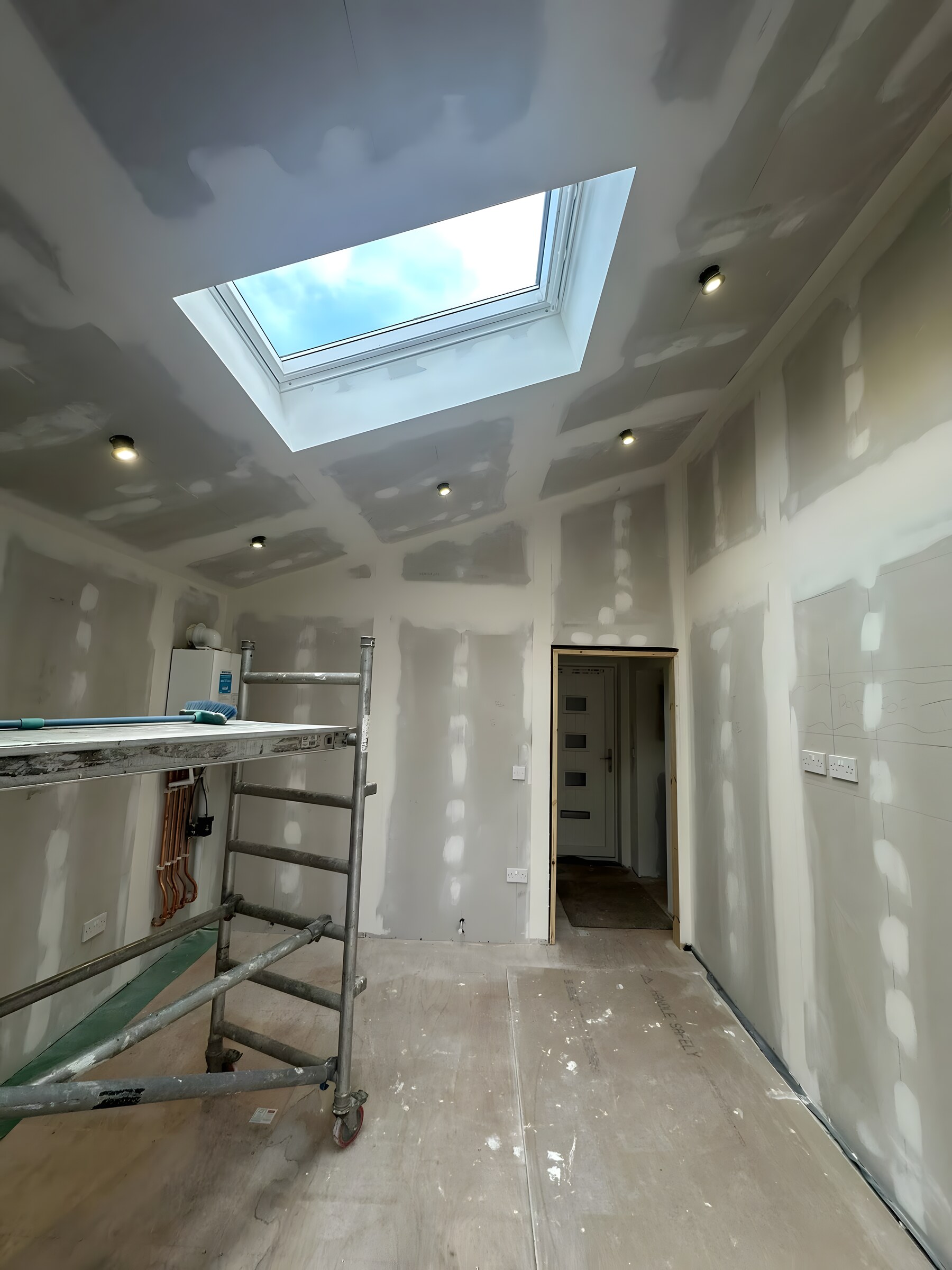 Boarded, taped and jointed, the roof light in — the plastering is ours as well