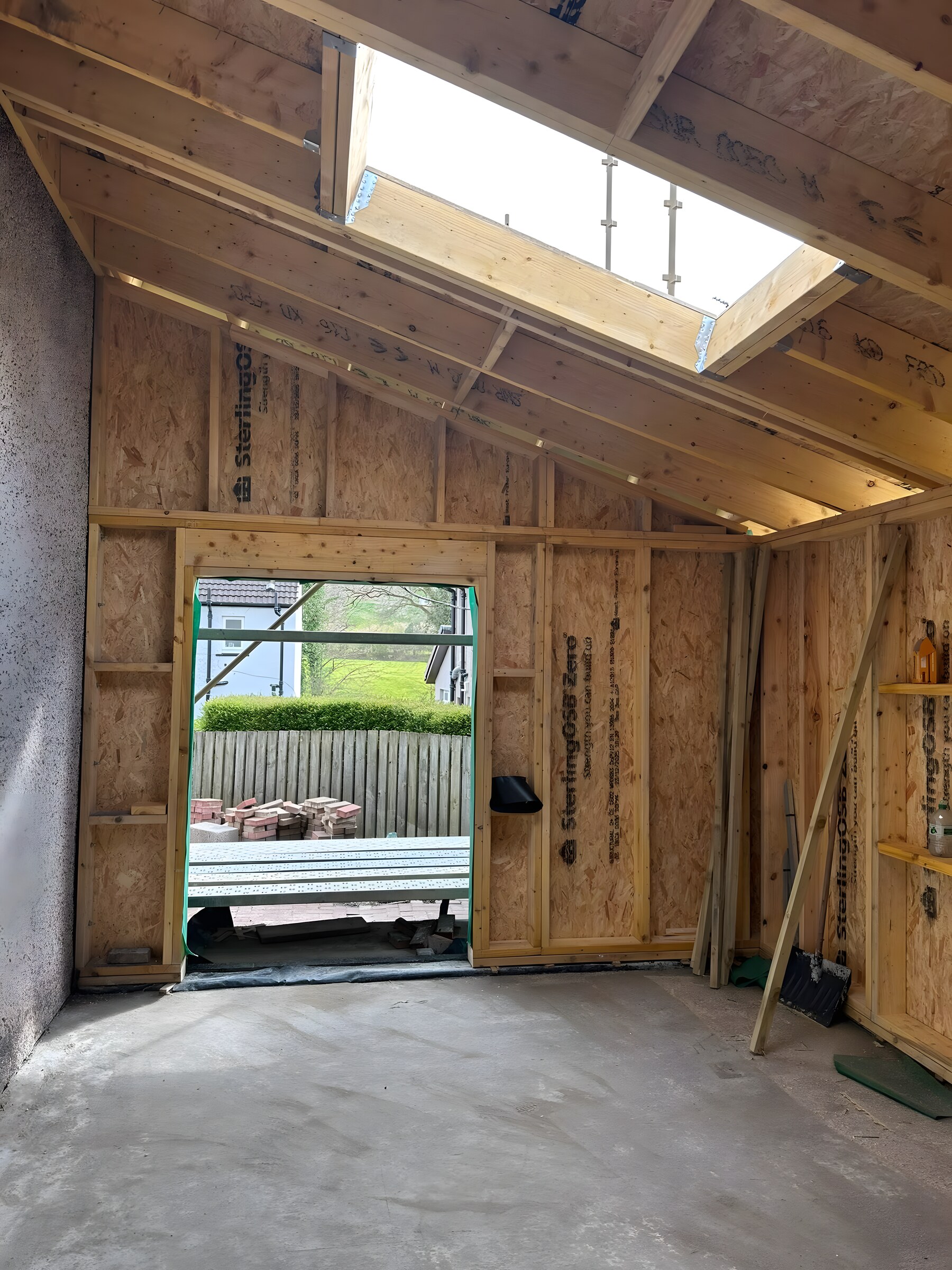 Inside the frame — OSB walls, the door opening and the roof-light opening