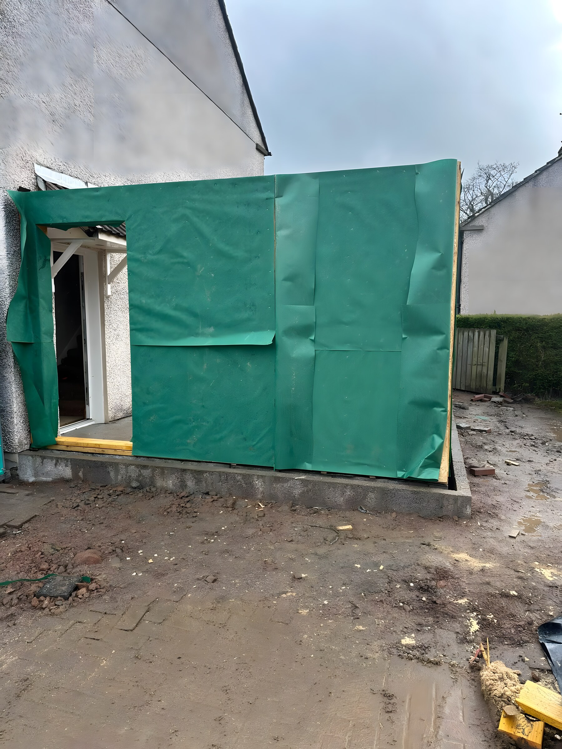 The frame up on the slab and wrapped in breather membrane