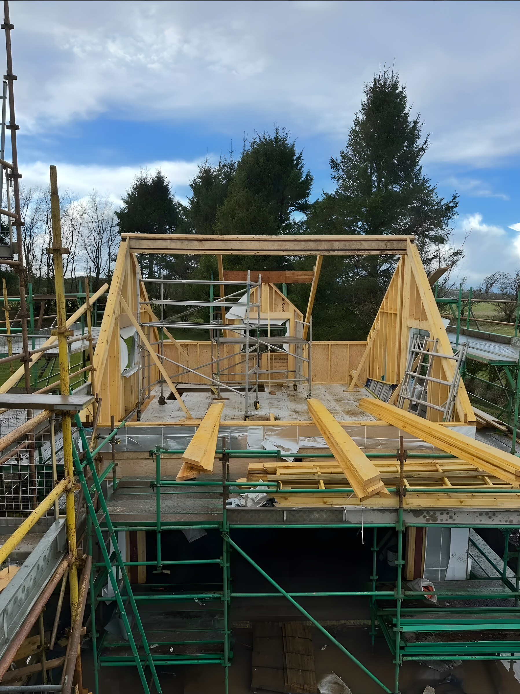 An upper-storey timber frame going up, both gables and the ridge beam in