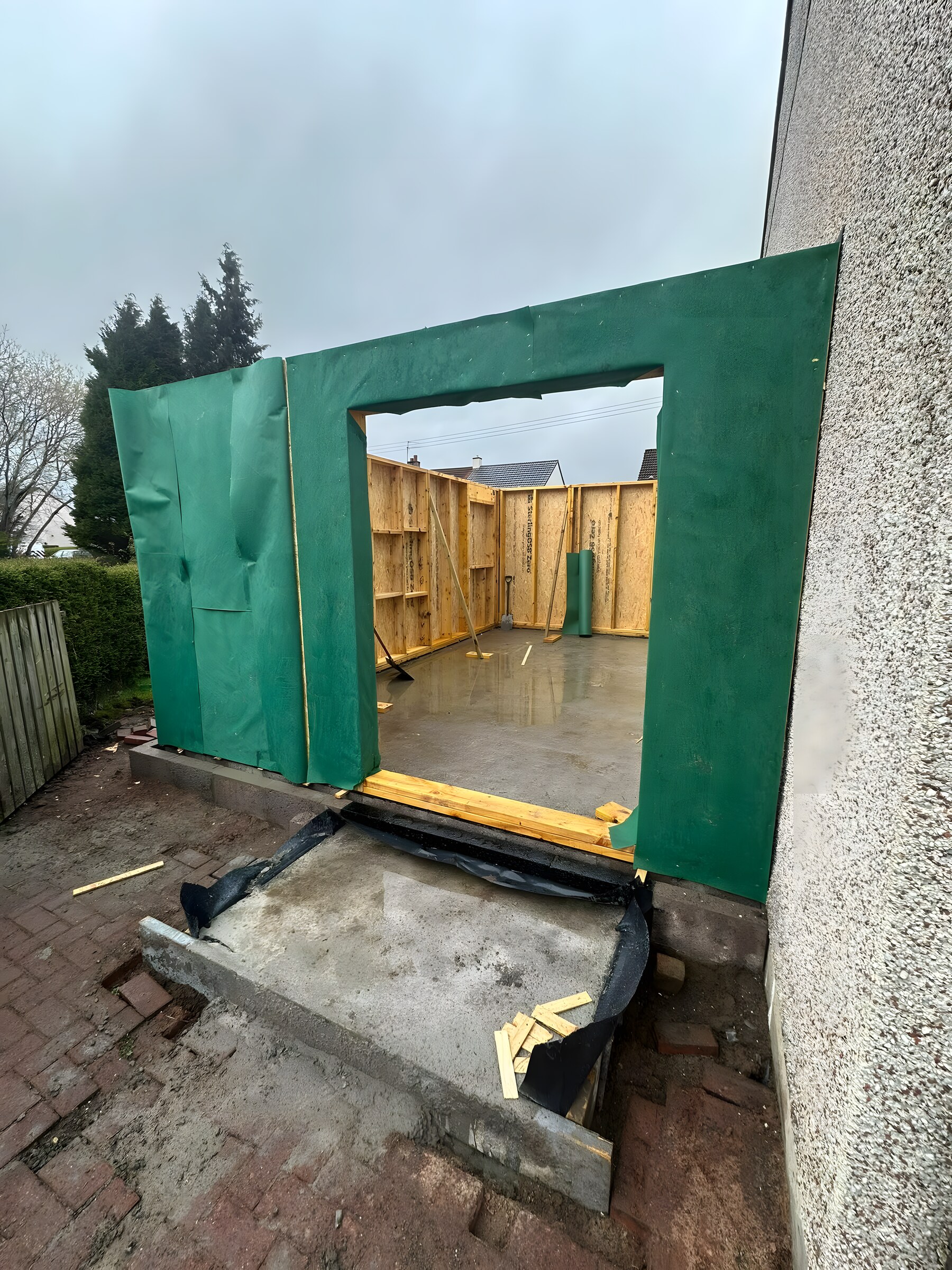 Timber frame up and wrapped, the door opening formed