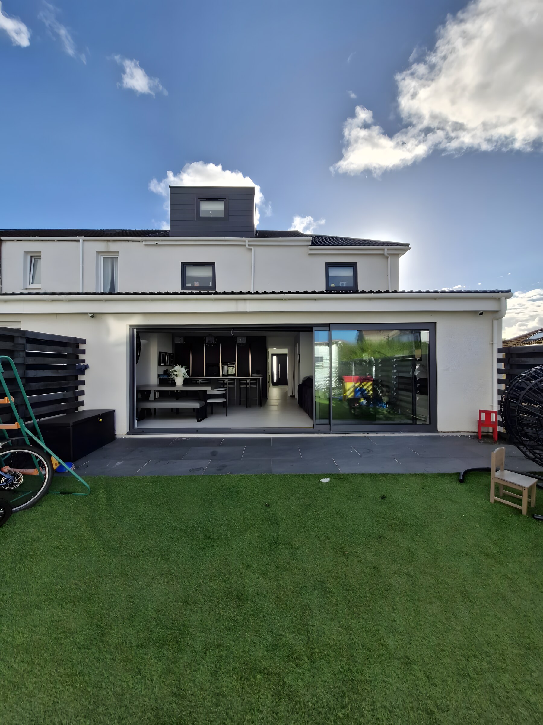 A rear extension with wide sliding doors, and a dormer above