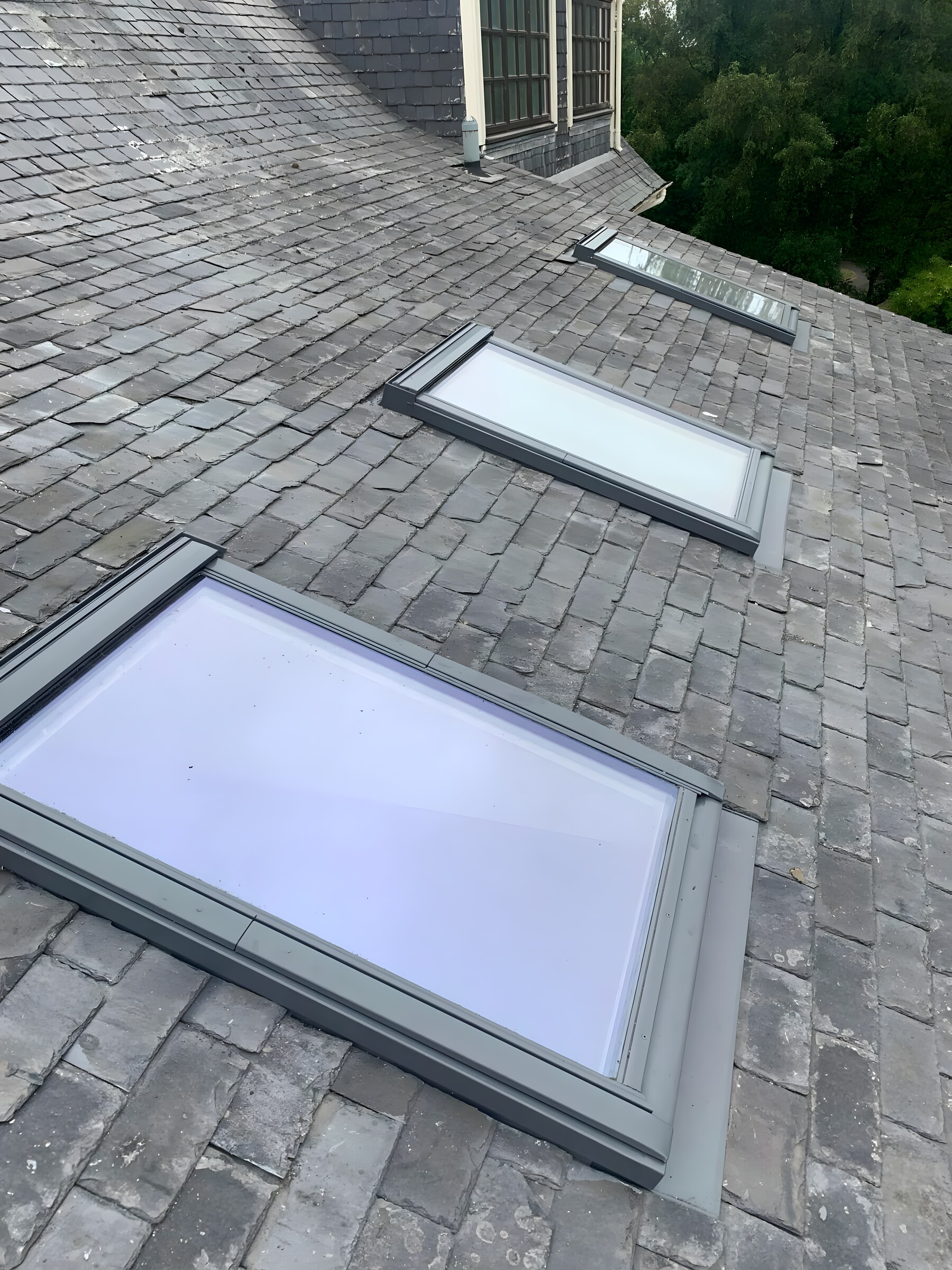 Three roof windows fitted into a slate roof