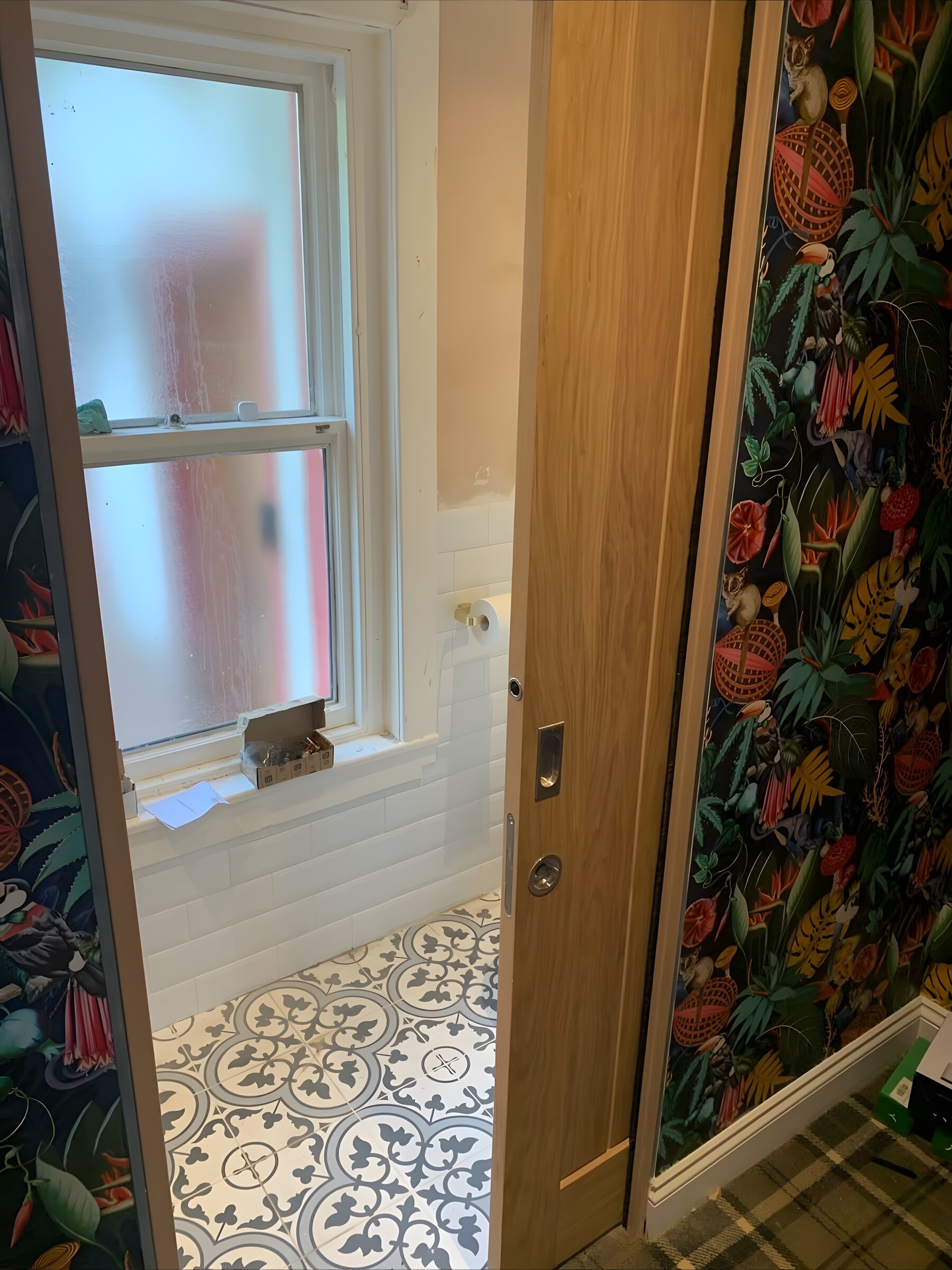 An oak sliding door, half open onto a bathroom