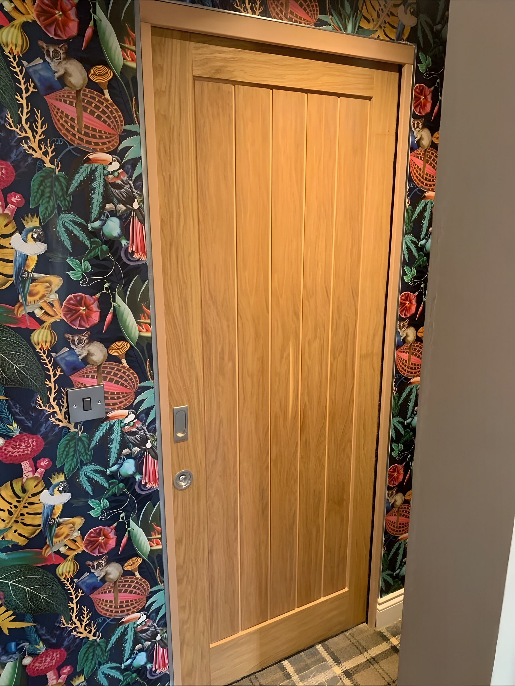 An oak sliding door, shut — a flush pull and a thumb turn