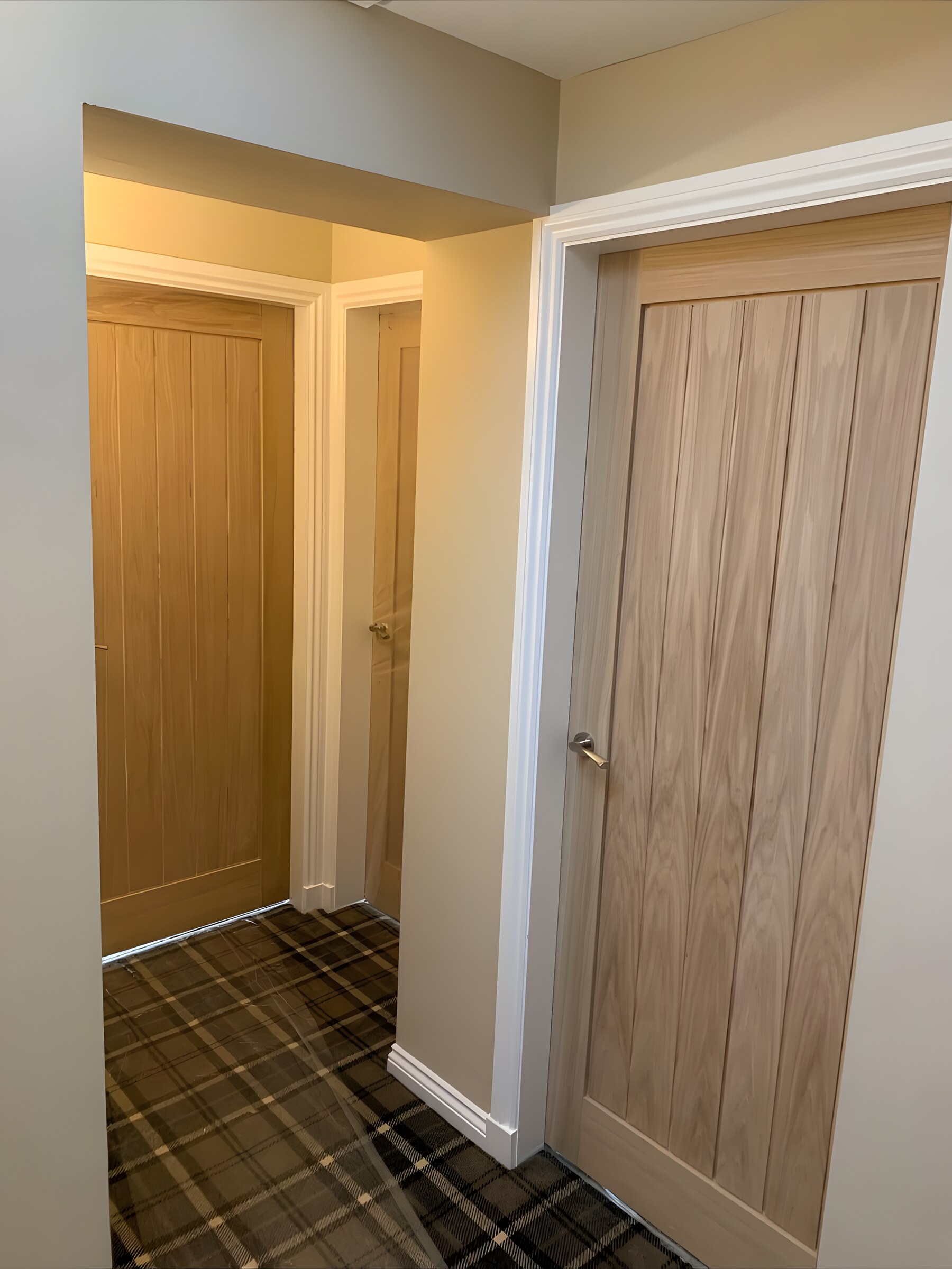 Oak doors off a hall with a tartan carpet