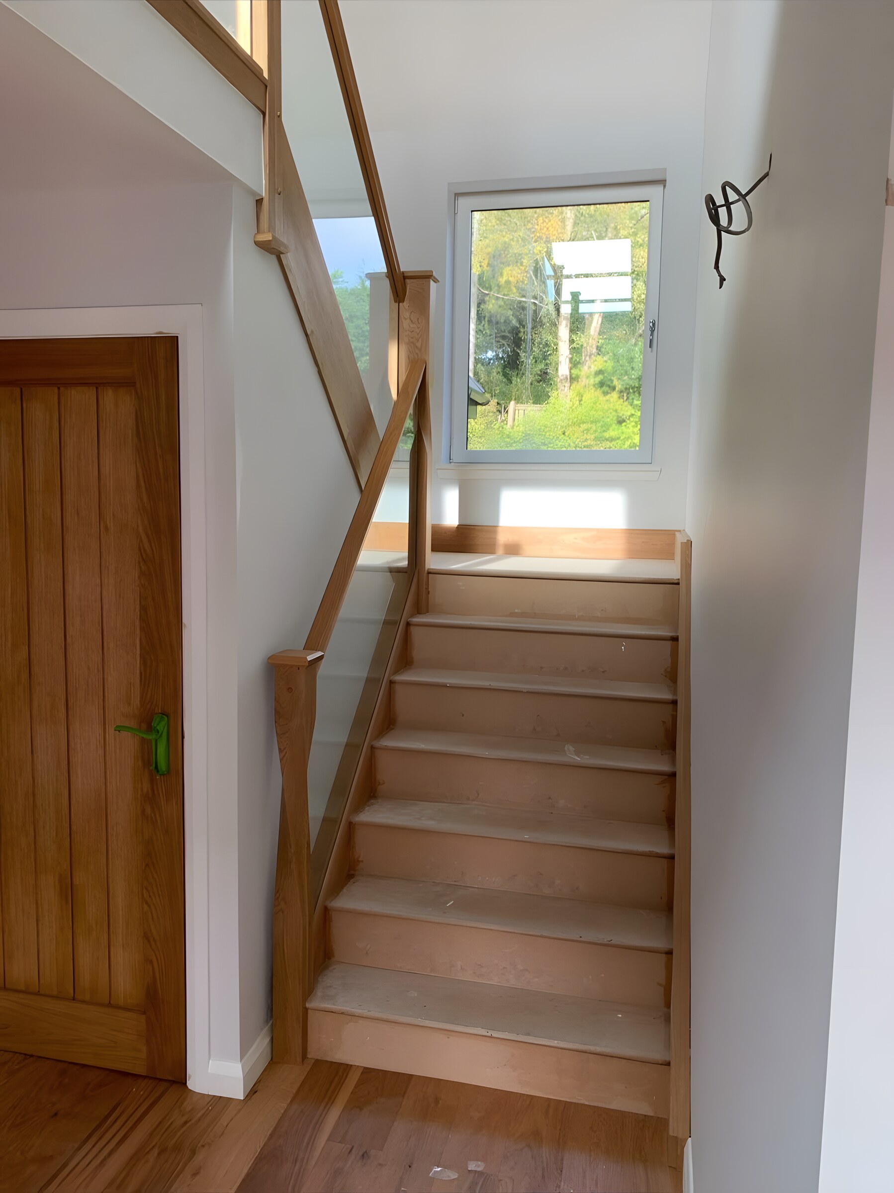 The stair from the hall, glass balustrade up to a window