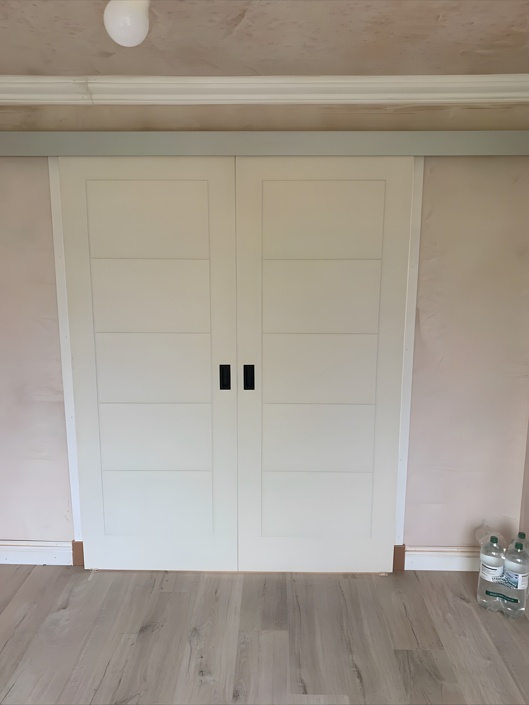 White double doors with black flush pulls, a pelmet across the top