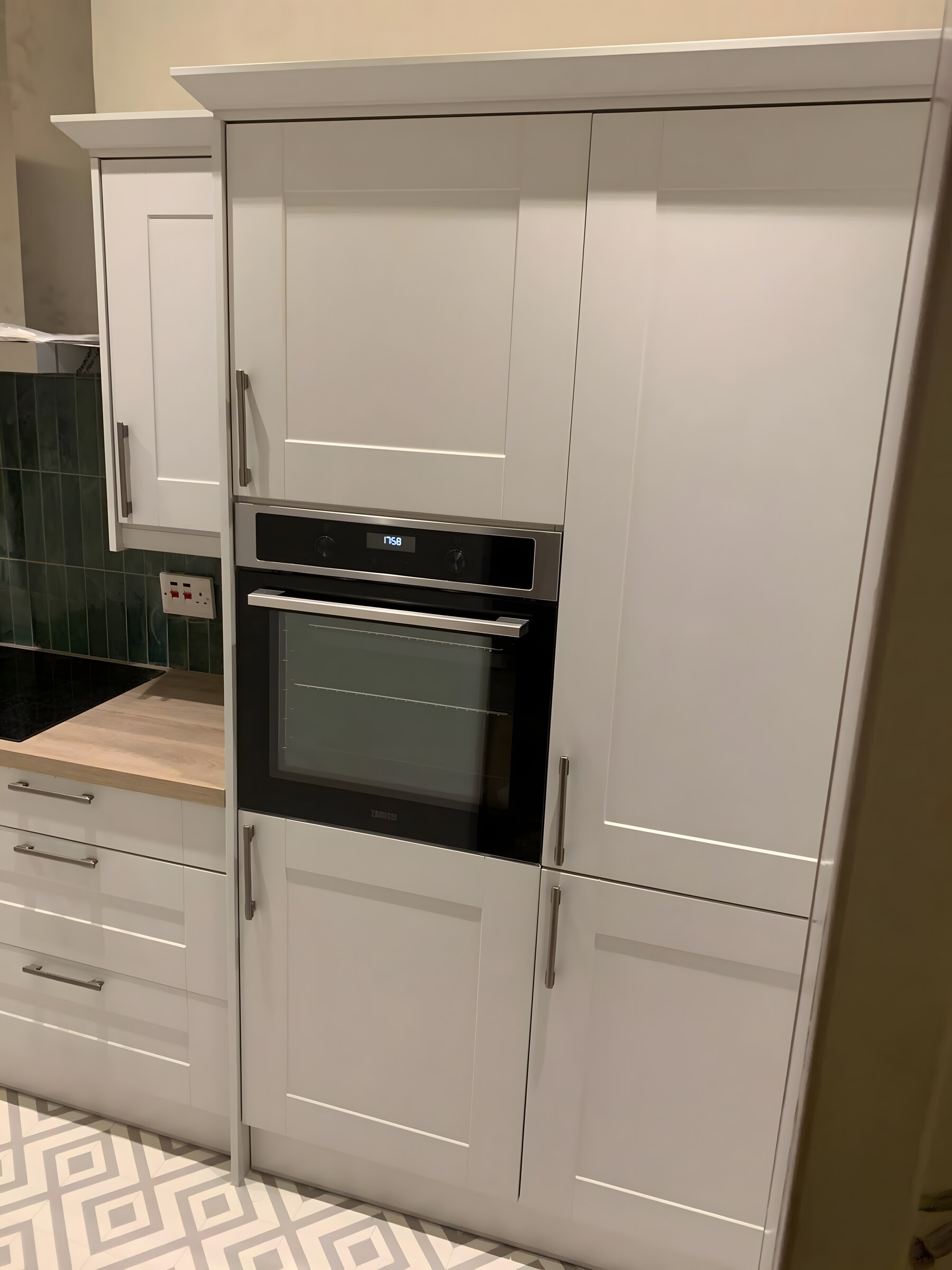 Painted shaker with the dark green tile — the oven housing