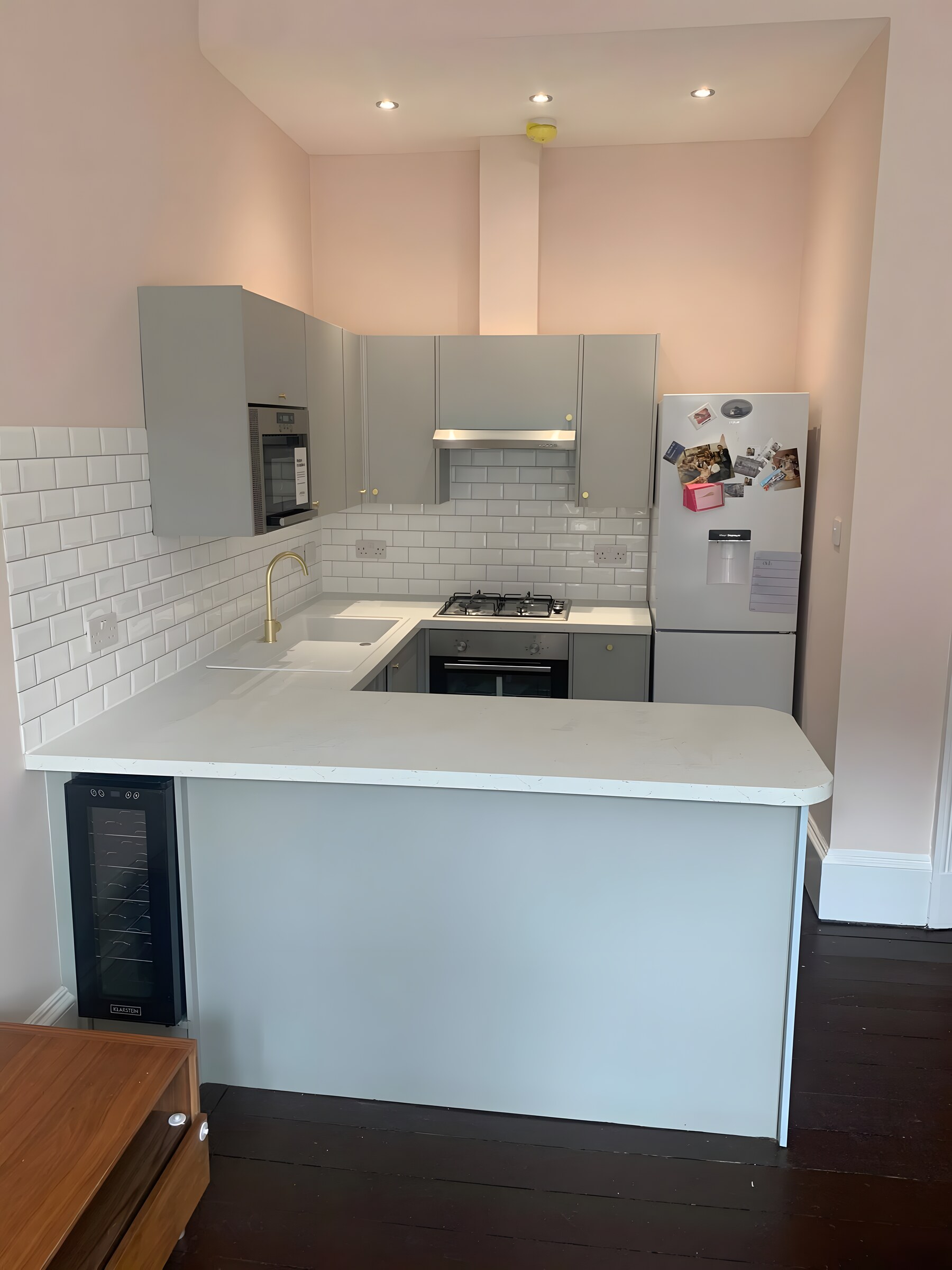 Grey units and brass knobs, white quartz, metro tile and a brass tap