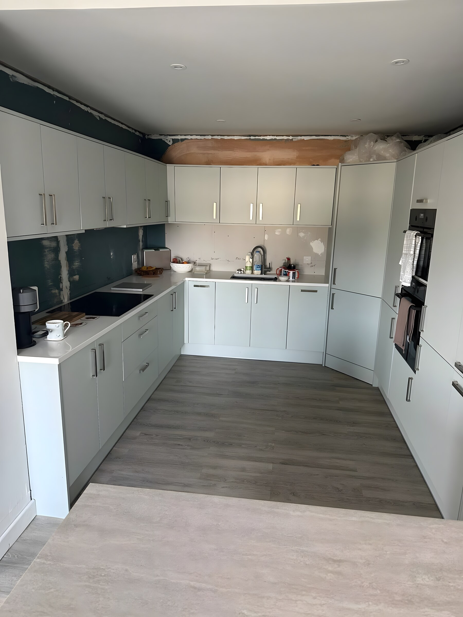 Pale green kitchen in a rear extension, just fitted