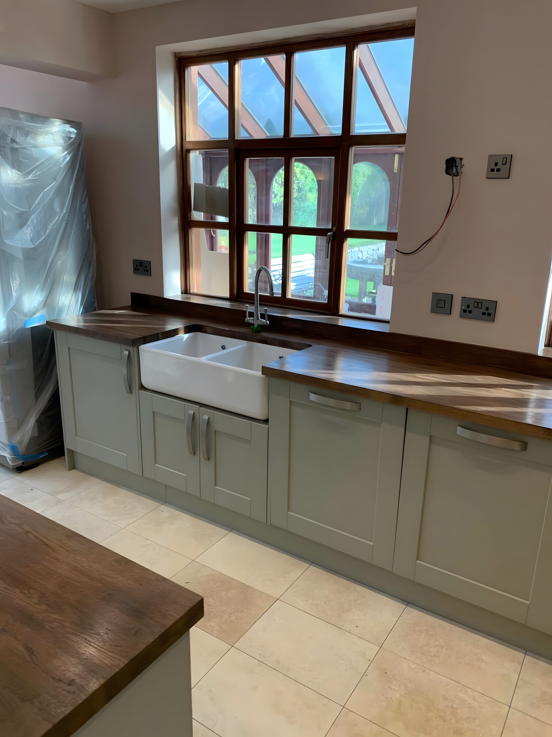 Same kitchen — the belfast sink under the window, walnut worktop